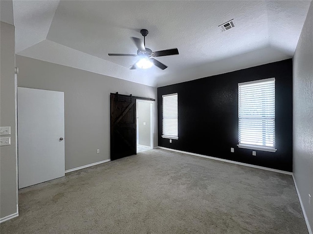 713 NW 143rd St, Edmond, OK 73013 - unfurnished bedroom with a barn door, carpet flooring, ceiling fan, a textured ceiling, and lofted ceiling