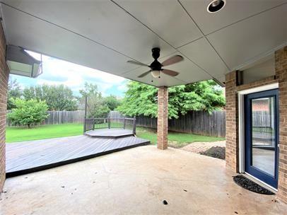 713 NW 143rd St, Edmond, OK 73013 - fenced backyard featuring a deck, a patio, and ceiling fan