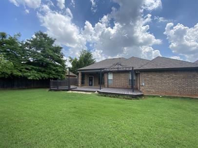 713 NW 143rd St, Edmond, OK 73013 - rear view of property with a deck and brick siding
