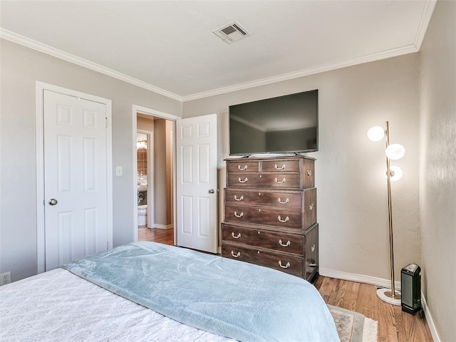 bedroom with visible vents, baseboards, crown molding, and wood finished floors