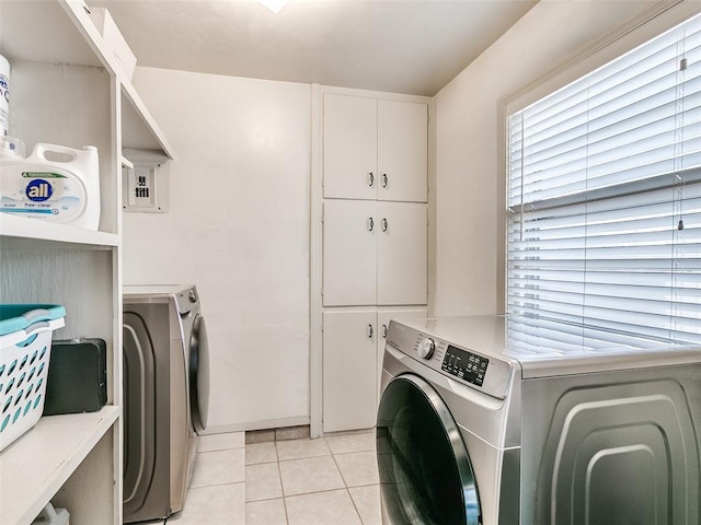 laundry room with light tile patterned floors, washer and clothes dryer, and laundry area