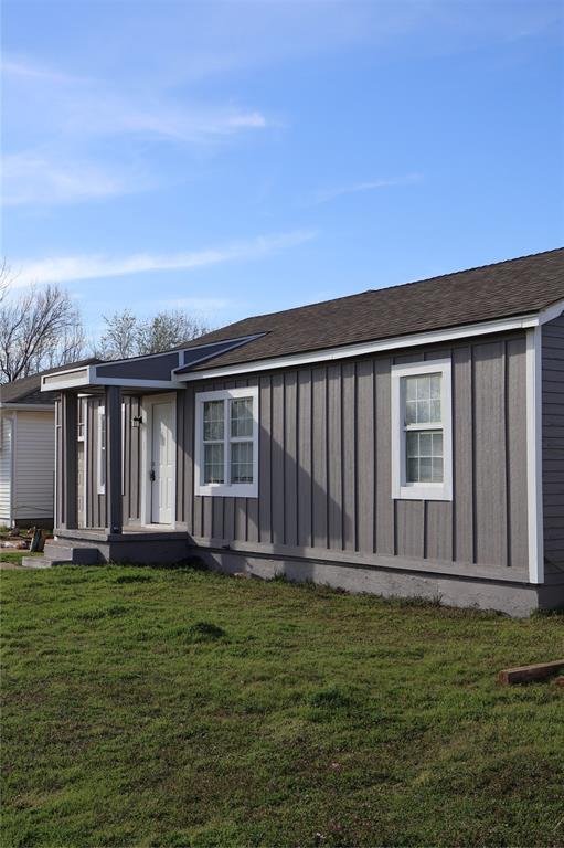view of front facade featuring board and batten siding and a front lawn