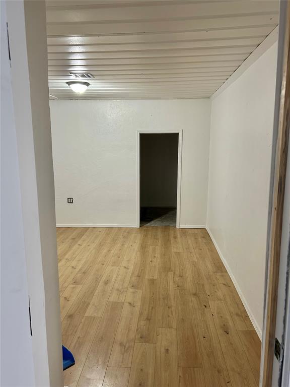 unfurnished room featuring baseboards and light wood-type flooring