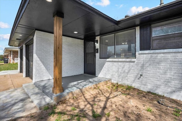 doorway to property featuring brick siding