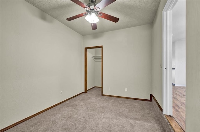 665 NW 15th St, Moore, OK 73160 - unfurnished bedroom featuring a textured ceiling, a walk in closet, light carpet, a closet, and a ceiling fan