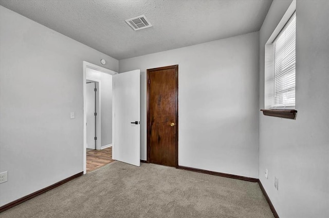 665 NW 15th St, Moore, OK 73160 - unfurnished bedroom featuring carpet floors and a textured ceiling