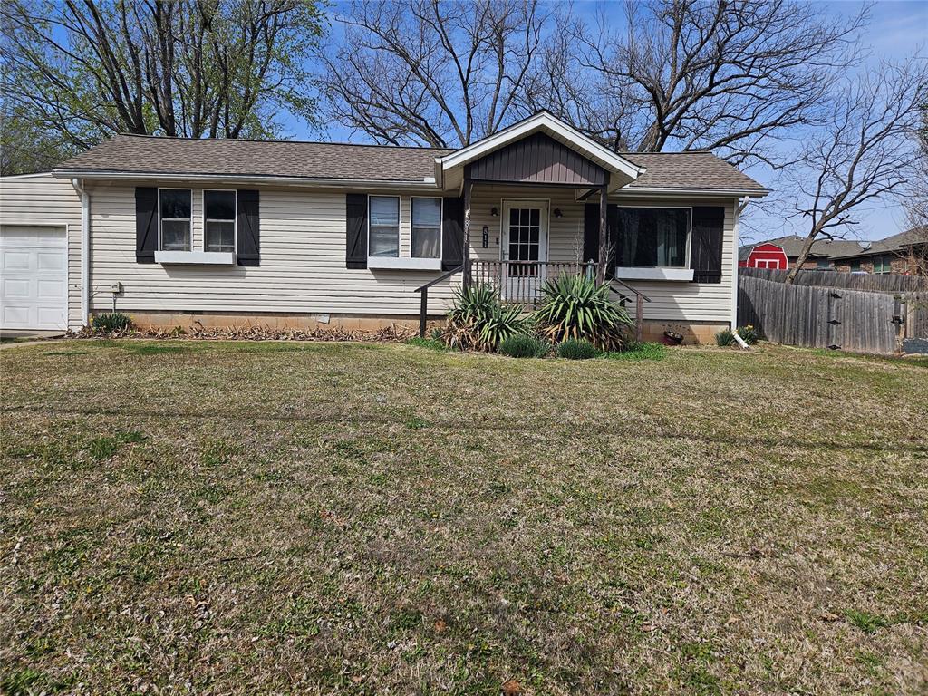 ranch-style house featuring fence, an attached garage, a shingled roof, crawl space, and a front yard