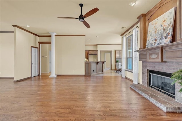 5405 NW 122nd Ter, Oklahoma City, OK 73162 - unfurnished living room featuring crown molding, light wood finished floors, a ceiling fan, a fireplace, and baseboards