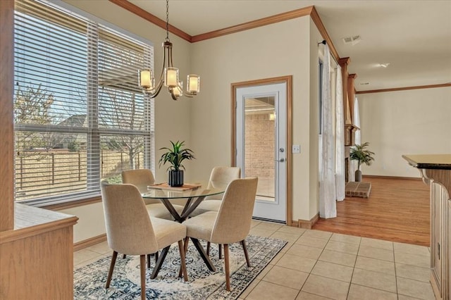 5405 NW 122nd Ter, Oklahoma City, OK 73162 - dining room with light tile patterned floors, a chandelier, plenty of natural light, ornamental molding, and baseboards