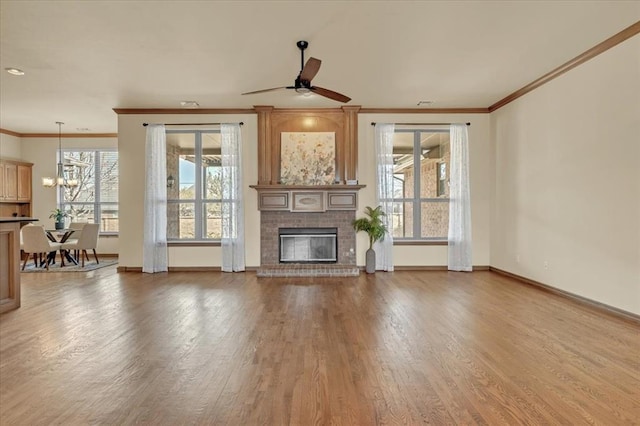 5405 NW 122nd Ter, Oklahoma City, OK 73162 - unfurnished living room featuring crown molding, a brick fireplace, wood finished floors, baseboards, and a ceiling fan
