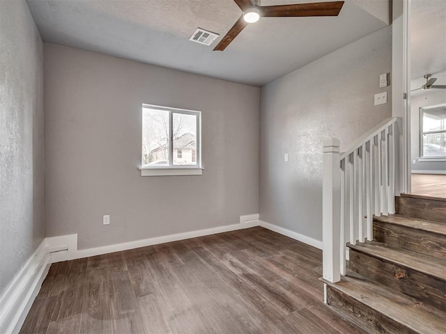 empty room featuring visible vents, wood finished floors, and a ceiling fan