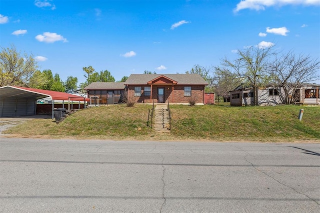 view of front of property featuring driveway, a carport, and a front yard