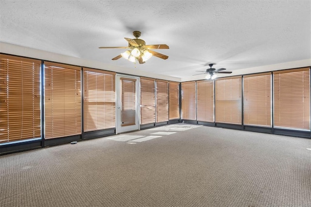 carpeted spare room with a textured ceiling and a ceiling fan