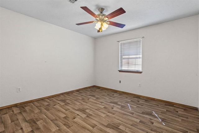 unfurnished room with baseboards, ceiling fan, and wood finished floors