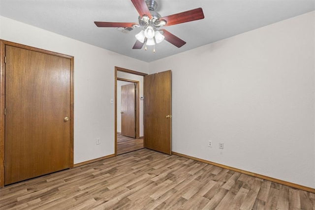 unfurnished bedroom featuring baseboards, light wood-style floors, visible vents, a ceiling fan, and a closet