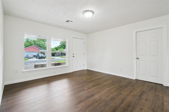 2233 SW 40th St, Oklahoma City, OK 73119 - unfurnished room featuring a textured ceiling, dark wood finished floors, and baseboards