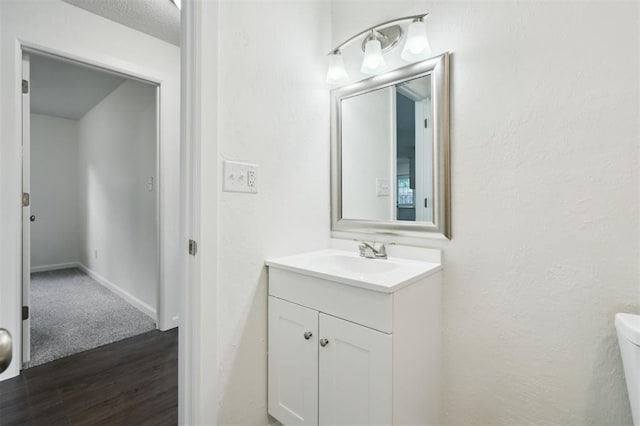 2233 SW 40th St, Oklahoma City, OK 73119 - half bathroom with vanity, toilet, wood finished floors, and baseboards
