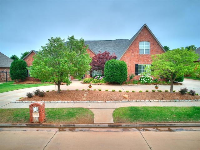 view of front of home featuring brick siding and roof with shingles