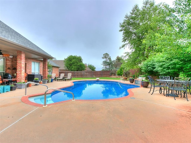 view of swimming pool with a fenced backyard, outdoor dining space, a patio, and a fenced in pool