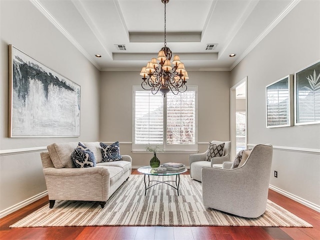 sitting room with visible vents, wood finished floors, a chandelier, and a raised ceiling