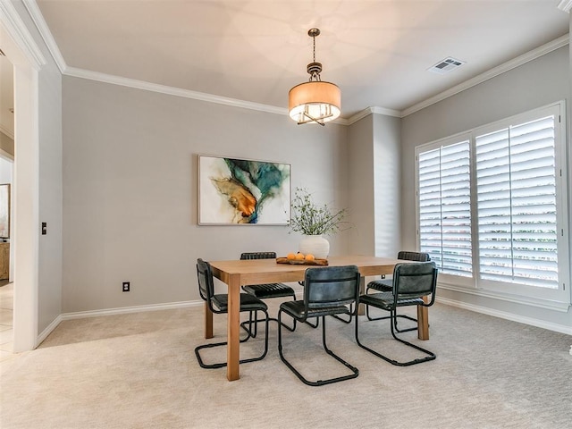 dining area with carpet floors, crown molding, baseboards, and visible vents