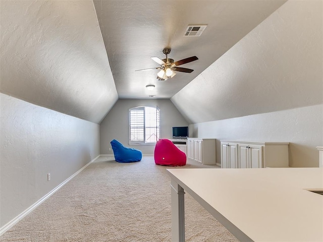 playroom featuring carpet floors, visible vents, vaulted ceiling, and a textured ceiling