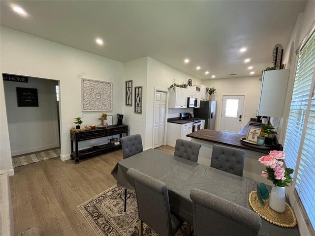 dining area featuring baseboards, light wood-type flooring, and recessed lighting