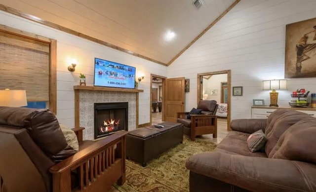 living area featuring high vaulted ceiling, a fireplace, and visible vents