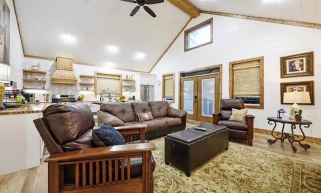 living area with beamed ceiling, a ceiling fan, french doors, and light wood-type flooring