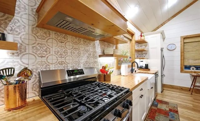 kitchen featuring white cabinets, lofted ceiling, open shelves, extractor fan, and stainless steel gas stove