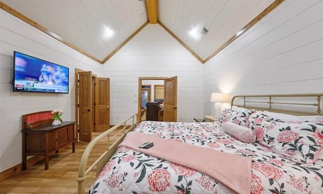 bedroom featuring high vaulted ceiling, wood finished floors, and beam ceiling
