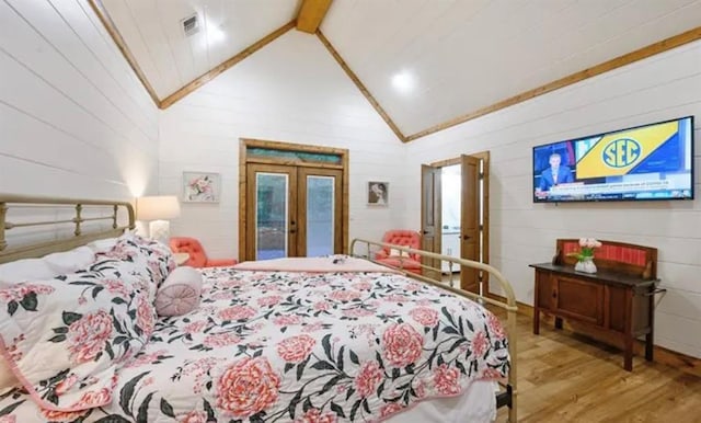 bedroom with visible vents, access to outside, wood finished floors, beam ceiling, and french doors