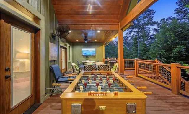 wooden terrace with outdoor dining space and ceiling fan