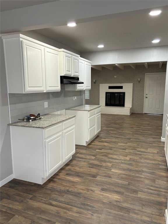 kitchen with recessed lighting, open floor plan, dark wood-style floors, white cabinets, and under cabinet range hood