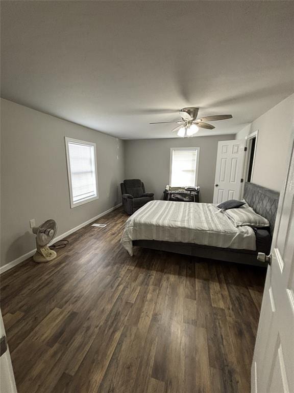 bedroom with a ceiling fan, baseboards, and dark wood finished floors