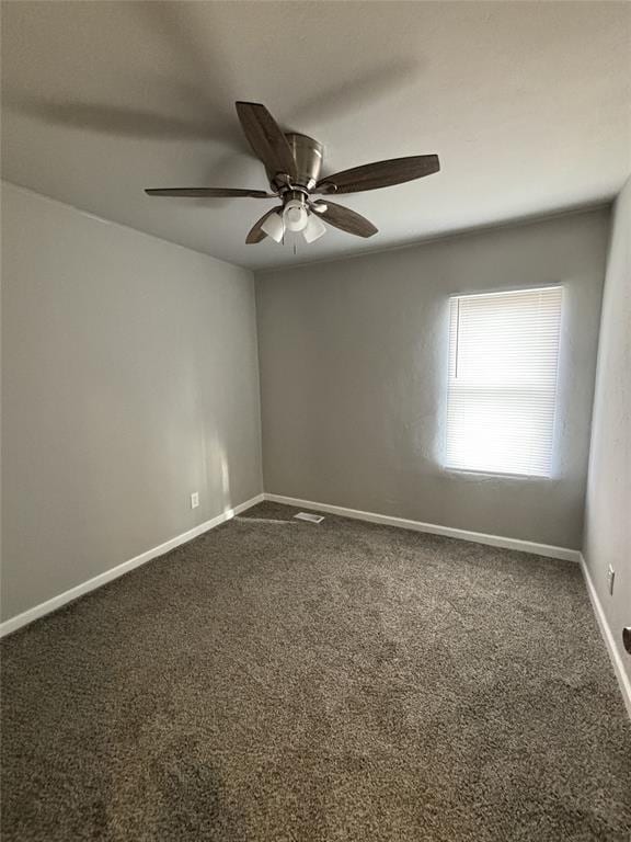 empty room with baseboards, a ceiling fan, and dark colored carpet