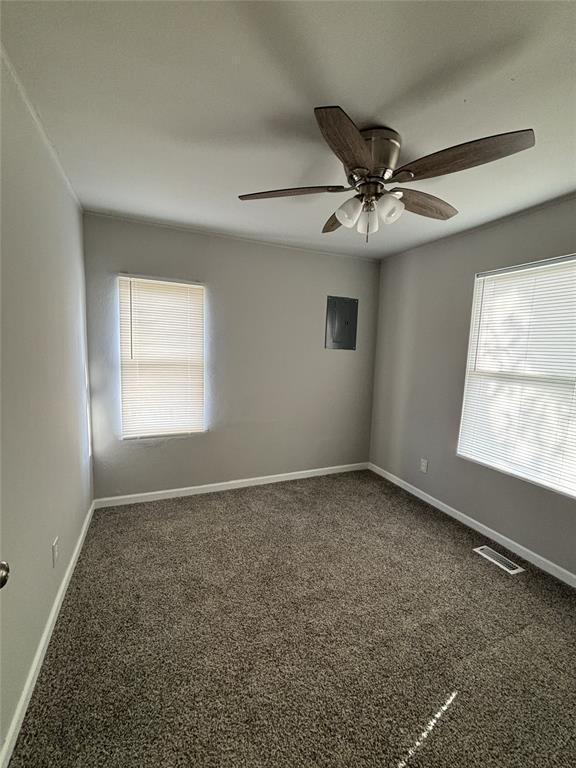 spare room featuring visible vents, baseboards, a ceiling fan, and carpet floors