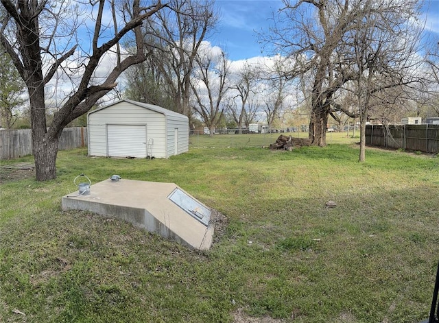 entry to storm shelter with a yard, a shed, a fenced backyard, and an outbuilding