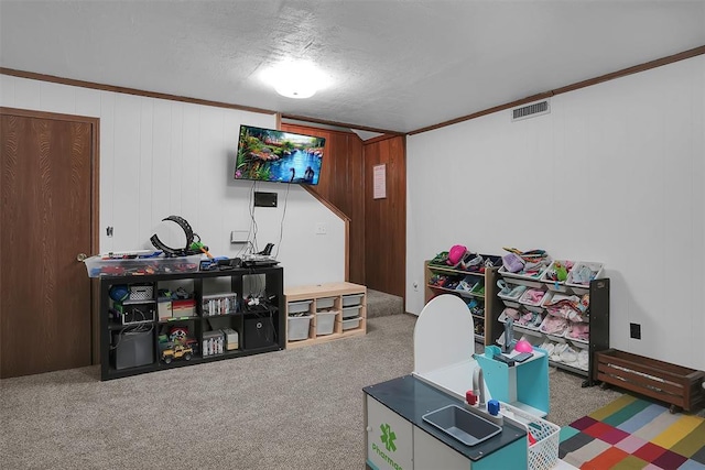 game room with visible vents, carpet flooring, and ornamental molding