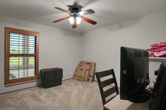 carpeted home office featuring baseboards, visible vents, and ceiling fan