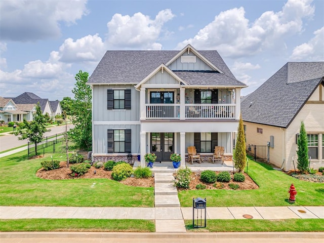 1924 Plaza District Dr, Edmond, OK 73034 - view of front of property with a balcony, fence, a front yard, board and batten siding, and french doors