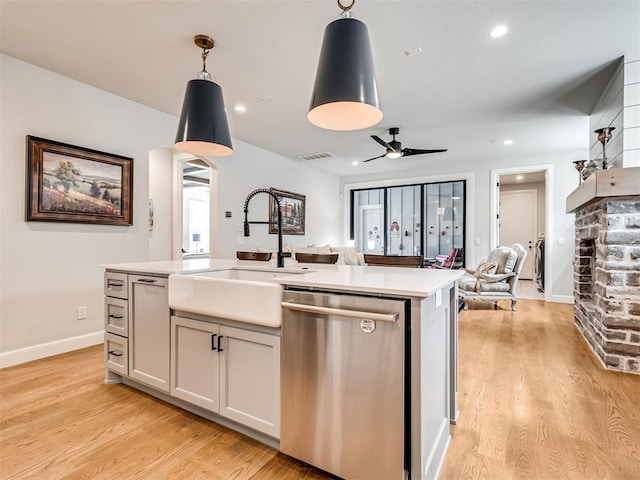 1924 Plaza District Dr, Edmond, OK 73034 - kitchen with open floor plan, light countertops, a sink, dishwasher, and a fireplace