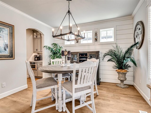 1924 Plaza District Dr, Edmond, OK 73034 - dining room with a chandelier, crown molding, light wood finished floors, baseboards, and arched walkways