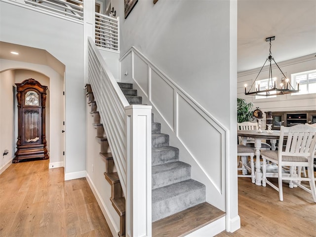 1924 Plaza District Dr, Edmond, OK 73034 - entrance foyer featuring light wood finished floors, a decorative wall, stairway, and an inviting chandelier