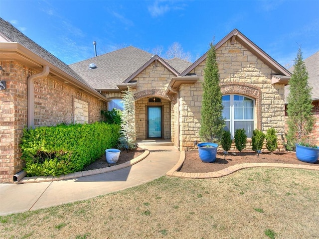 2809 Morgan Trace Rd, Yukon, OK 73099 - doorway to property featuring stone siding, roof with shingles, and a lawn