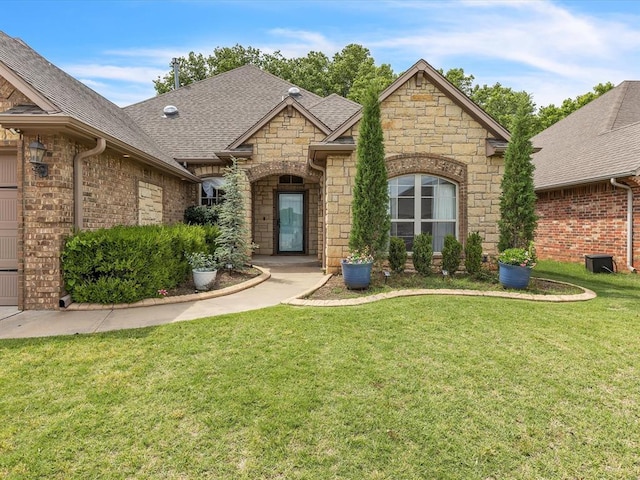 2809 Morgan Trace Rd, Yukon, OK 73099 - view of front of home with stone siding, a shingled roof, and a front lawn