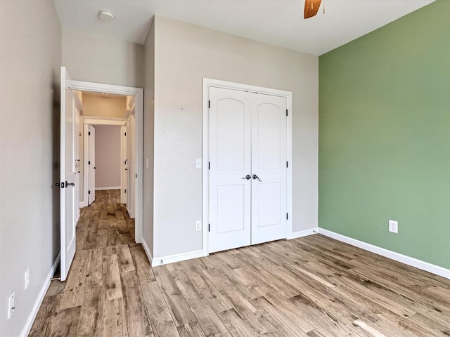 2809 Morgan Trace Rd, Yukon, OK 73099 - unfurnished bedroom with wood finished floors, a closet, baseboards, and a ceiling fan
