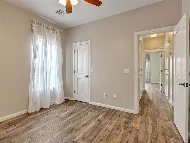 2809 Morgan Trace Rd, Yukon, OK 73099 - unfurnished bedroom featuring wood finished floors, baseboards, and ceiling fan