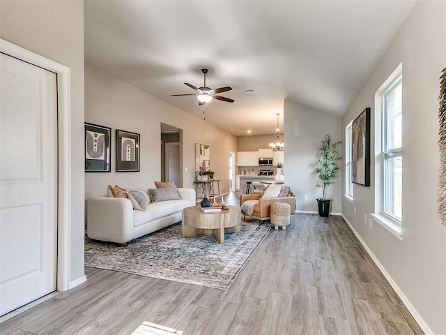 3721 Central Park Dr, Moore, OK 73160 - living area featuring a ceiling fan, a chandelier, light wood finished floors, lofted ceiling, and baseboards