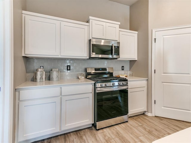3721 Central Park Dr, Moore, OK 73160 - kitchen with stainless steel appliances, backsplash, white cabinets, light countertops, and light wood-type flooring